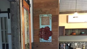 A rustic kitchen with wooden walls, a vintage door, and a decorative wall piece. - Rustic luxury deep in the heart of Texas  (Hamilton)
