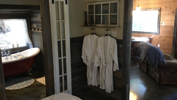 A room with a bathtub, a bed, and a wooden bench. - Rustic luxury deep in the heart of Texas  (Hamilton)