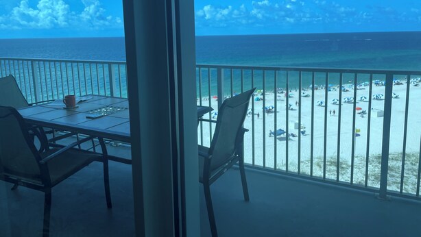 Ein Balkon mit Blick auf Strand und Meer.