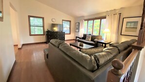 A living room with a large sectional sofa, a coffee table, a TV on a stand, and a fireplace.