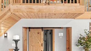 A loft-style room with a wooden balcony, a dining area set with autumn-themed decorations, and a staircase leading to a second level. - Summer DISCOUNT Belleayre Mountain House, Catskills (Fleischmanns Heights)