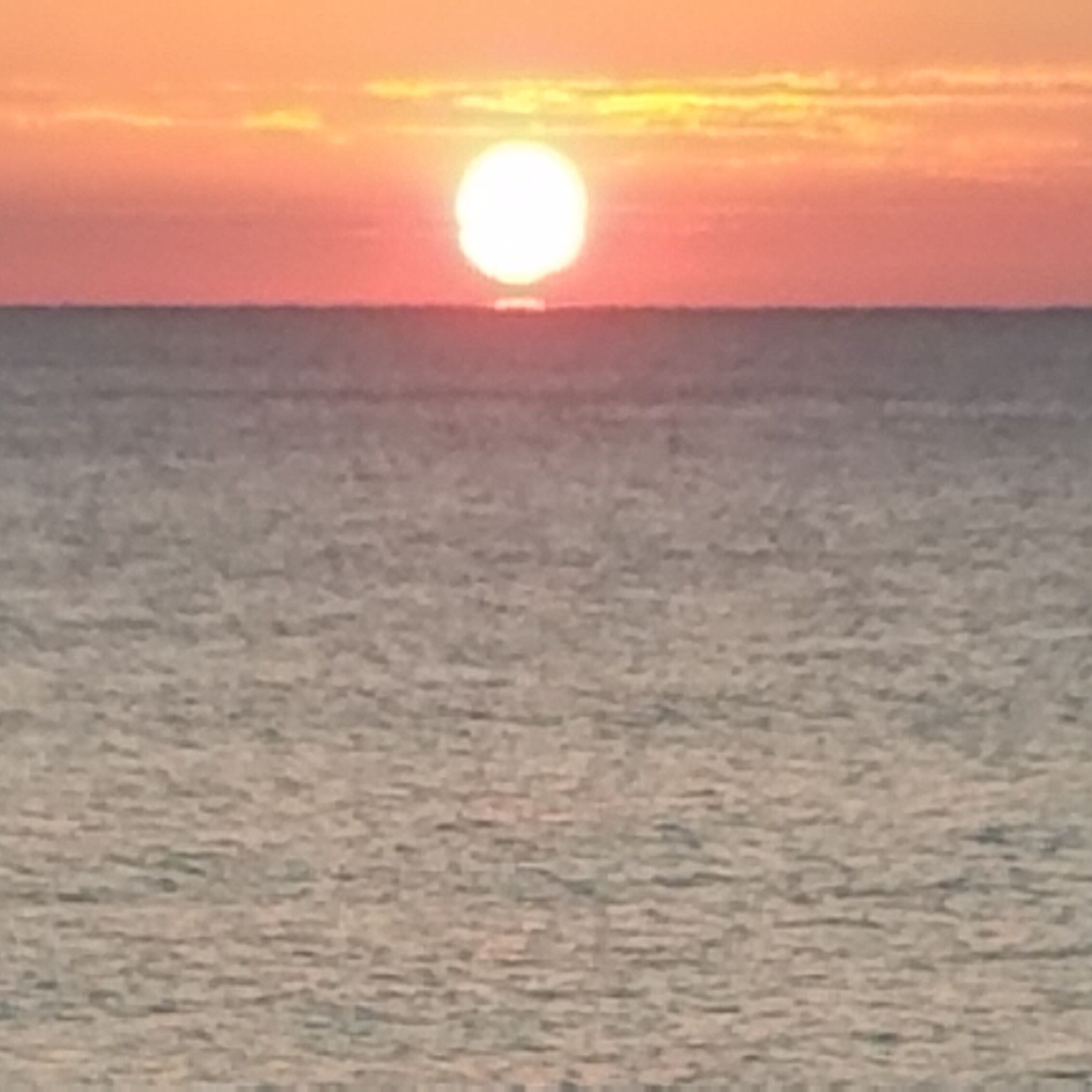 A sunset over a calm sea.
