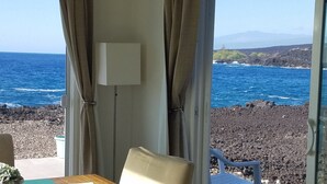 Una habitación con vista al océano y a la costa rocosa.
