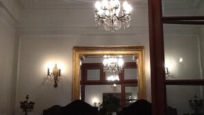 En matplats med en kristallkrona, en spegel med träram och vägglampor.