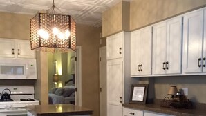 A kitchen with white cabinets, a central island, a microwave, stove, and a hanging light fixture. - Mansions, History, and Shops at your doorstep! Walk to 40+ restaurants & pubs (St. Paul)