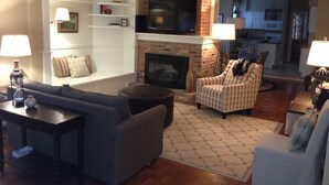 A living room with a fireplace, a television, and a sofa. - Mansions, History, and Shops at your doorstep! Walk to 40+ restaurants & pubs (St. Paul)