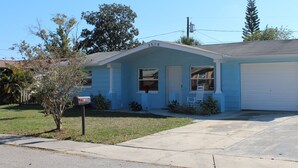 A single-story house with a garage, a mailbox, and a small front yard.