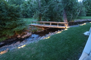 A wooden bridge over a stream in a wooded area.