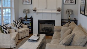 A living room with a fireplace, two sofas, a coffee table, and decorative lamps.