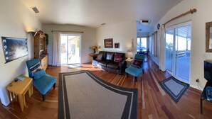 A spacious living room with a sofa set, a coffee table, and a fireplace. There is a large window providing natural light and a view of the outdoors. - Beautiful Views Overlooking Moab Valley! (Moab)