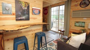 Un interior de madera con una zona de bar, un sofá y una señal de pare.