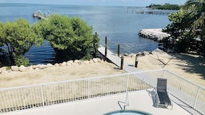 A swimming pool with a view of the sea and a beach area. - Sunset Catch- Gulf Front, Open Water Views, Private Pool and Dock, Kayaks. (Marathon)