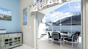 A conservatory with a glass ceiling, a dining area with a table and chairs, and a cabinet with drawers and shelves. - Fairytale Villa - 2 Masters, Privacy Fence! (Kissimmee)