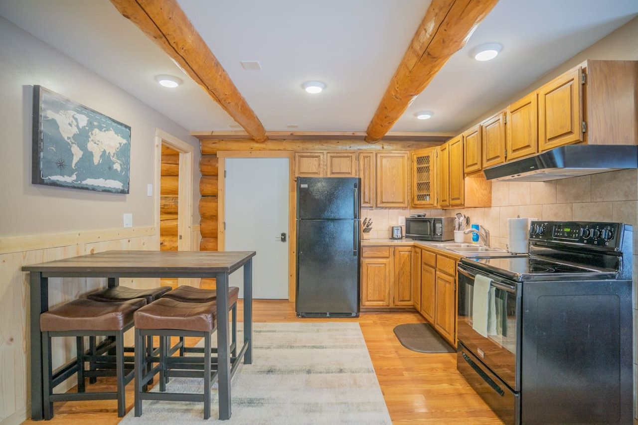 A kitchen with wooden cabinets, a refrigerator, a stove, and a microwave.