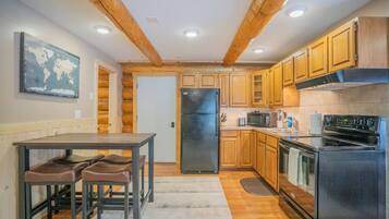 A kitchen with wooden cabinets, a refrigerator, a stove, and a microwave.