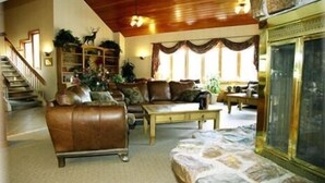 A spacious living room with a fireplace, leather sofas, a coffee table, and a staircase. - Ski-in Ski-Out:King in Master; Quiet End Unit; high speed secure internet (Winter Park)