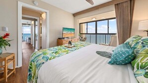 Ein Hotelzimmer mit Bett, Deckenventilator, Blick auf den Balkon und einem Bild an der Wand.