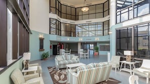 A spacious lobby with a high ceiling, multiple seating areas, and large windows providing natural light. - Escape to the Beach! Phoenix 8, 1402, 2 BR/2 Bath (Orange Beach)