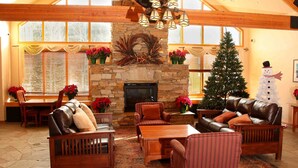 A spacious living room with a stone fireplace, leather sofas, and a Christmas tree. - 4BR4BA Keystone Condo Rental, Walk to Lifts.. GreatRentalKeystone in The Gateway (Keystone)