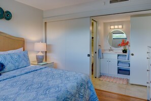 Ein Schlafzimmer mit einem Bett, einem Nachttisch, einer Lampe und einem Kleiderschrank.
