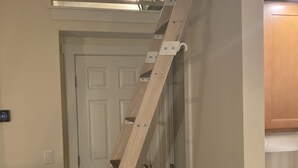 Una escalera de madera que conduce a una zona superior con vistas al cielo.