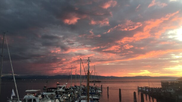 Un puerto deportivo con barcos amarrados bajo un cielo al atardecer.