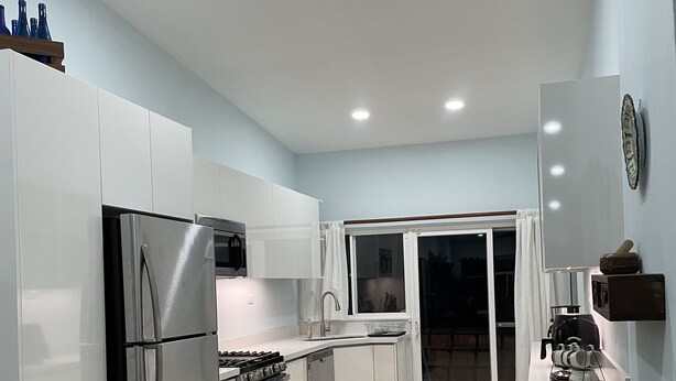 A modern kitchen with white cabinets, stainless steel appliances, and a tiled floor. - Private home with pool and only a block to the beach, restaurants, nightlife... (Jaco Beach)
