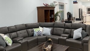 A modern living room with a sectional sofa, a wooden coffee table, and a ceiling fan. - Private home with pool and only a block to the beach, restaurants, nightlife... (Jaco Beach)