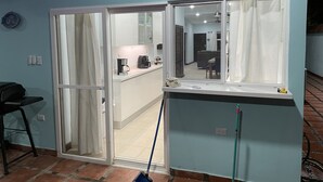 A room with a sliding door leading to a kitchen area, a dining table, and a sofa. - Private home with pool and only a block to the beach, restaurants, nightlife... (Jaco Beach)