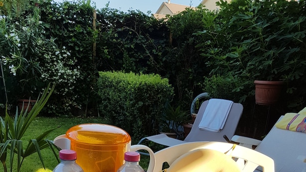 A table set outdoors with various food items, including a basket of bread, a bottle of water, and containers of yogurt. - B&B La Delice (Dalmine)