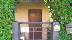 A gated entrance with a metal gate and a wooden door, surrounded by lush green foliage. - B&B La Delice (Dalmine)