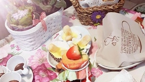 A table with various pastries, including croissants and a layered cake, alongside a basket of bread and a coffee cup. - B&B La Delice (Dalmine)