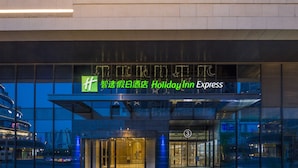 A Holiday Inn Express hotel entrance with a glass facade and illuminated signage. - Holiday Inn Express Suzhou New District by IHG (Suzhou)