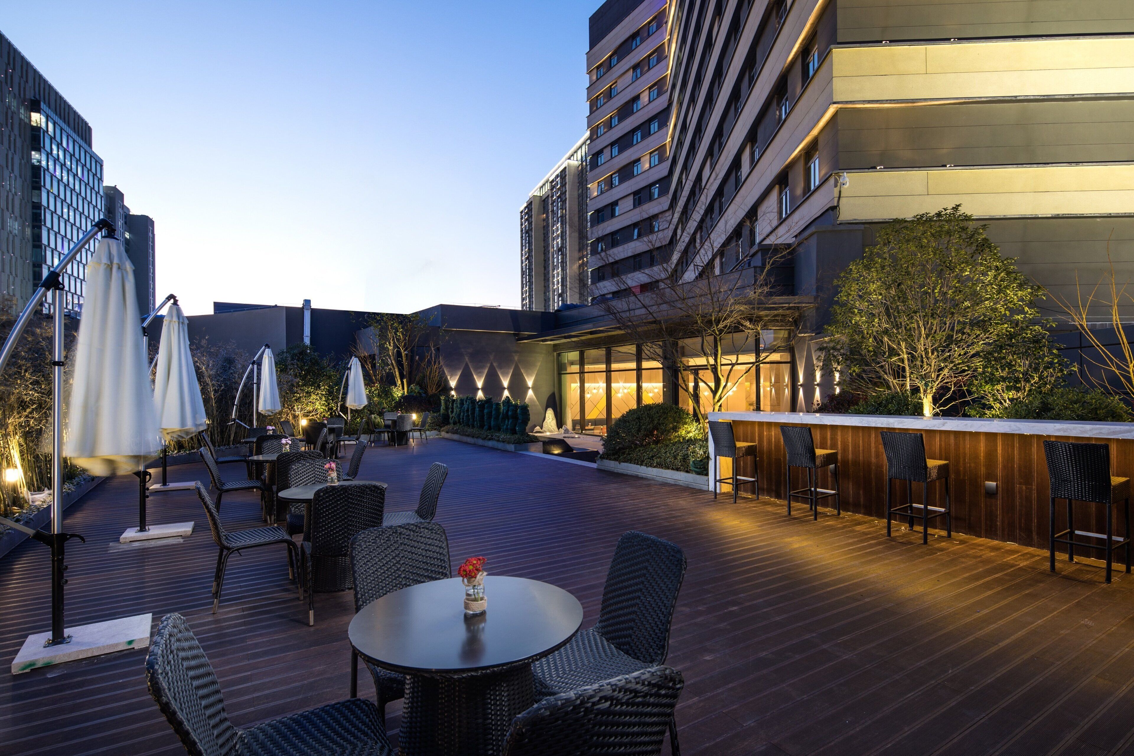 An outdoor patio area with tables and chairs, surrounded by buildings.