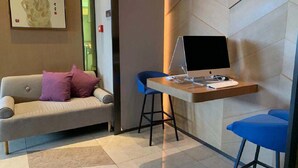 A modern room with a sofa, a desk with a laptop, and a chair. - Holiday Inn Express Suzhou New District by IHG (Suzhou)