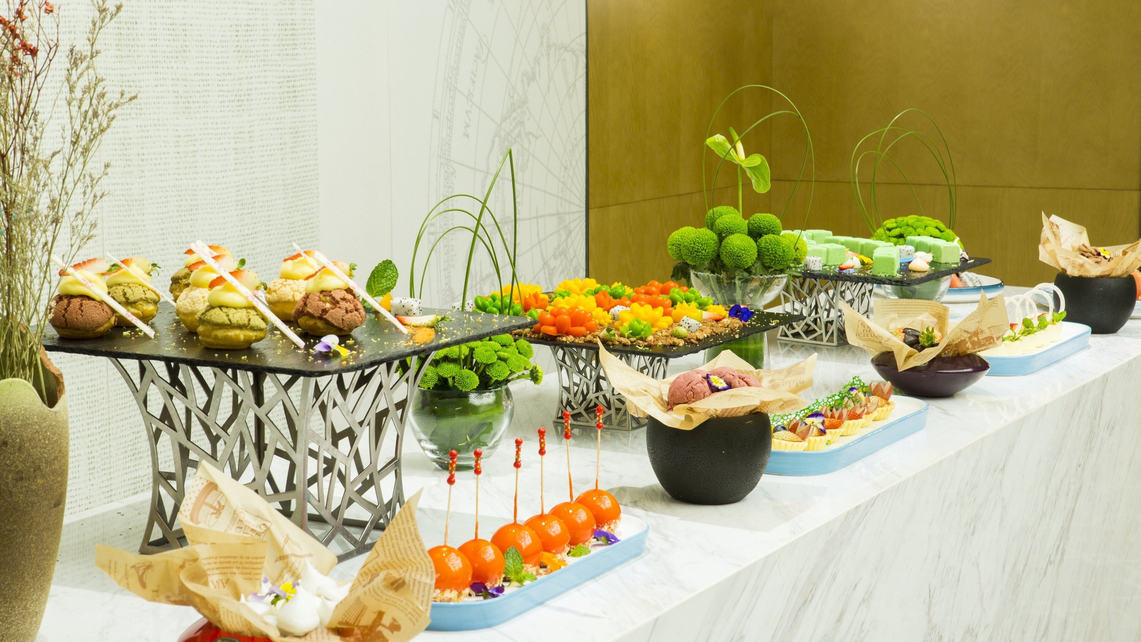 A buffet table with various food items and decorative elements.