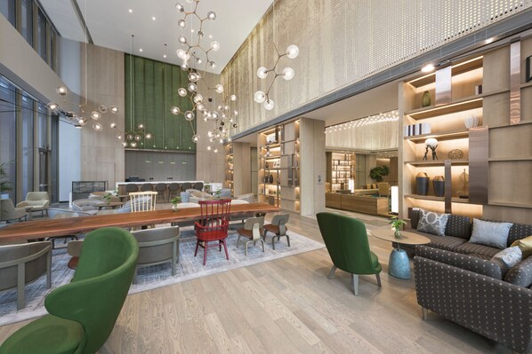 A modern hotel lobby with a bar area, seating arrangements, and a large window providing natural light. - Holiday Inn Hotel & Suites Tianjin Downtown by IHG (Tianjin)