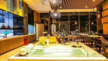 A modern restaurant interior with a central glass display, wooden accents, and a large window.