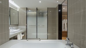 A modern bathroom with a large bathtub, a glass shower enclosure, and a vanity with a mirror. - Holiday Inn Hotel & Suites Tianjin Downtown by IHG (Tianjin)