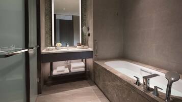 Un baño moderno con cabina de ducha de vidrio, una bañera independiente y un tocador con un espejo grande.