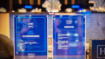 Two informational signs with text in English and Chinese, placed on a counter.