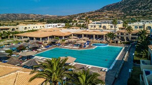 Et resort med en stor swimmingpool, liggestole og palmer.