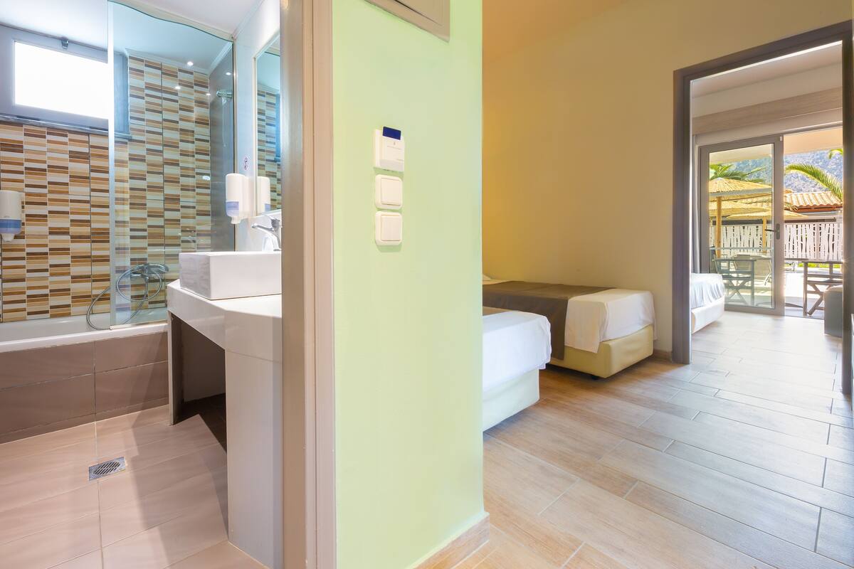 A bathroom with a bathtub, toilet, and sink. There is a window above the bathtub and a mirror above the sink.