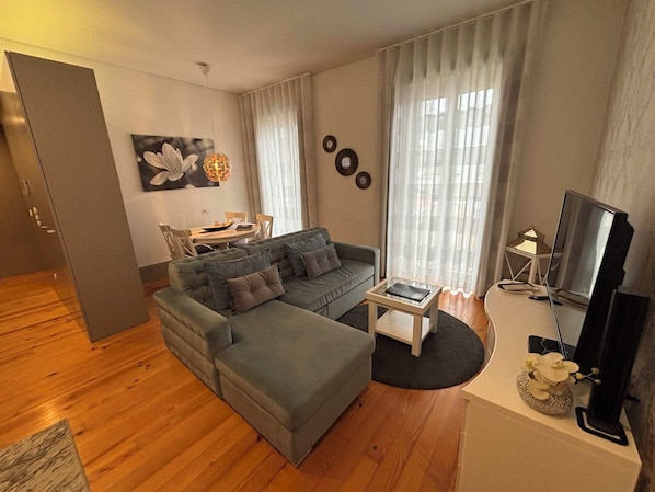 A modern living room with a sectional sofa, a coffee table, and a television.