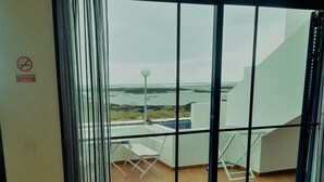 A balcony with a view of the sea, a white chair, and a table. - Brisamarina de Órzola (Orzola)