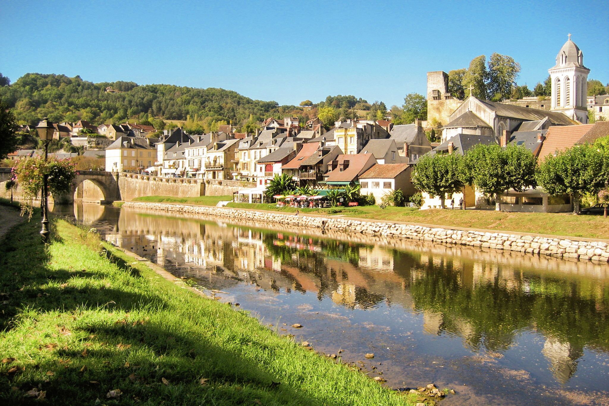 Une ville riveraine dotée de bâtiments historiques, d’un pont et d’un clocher d’église.