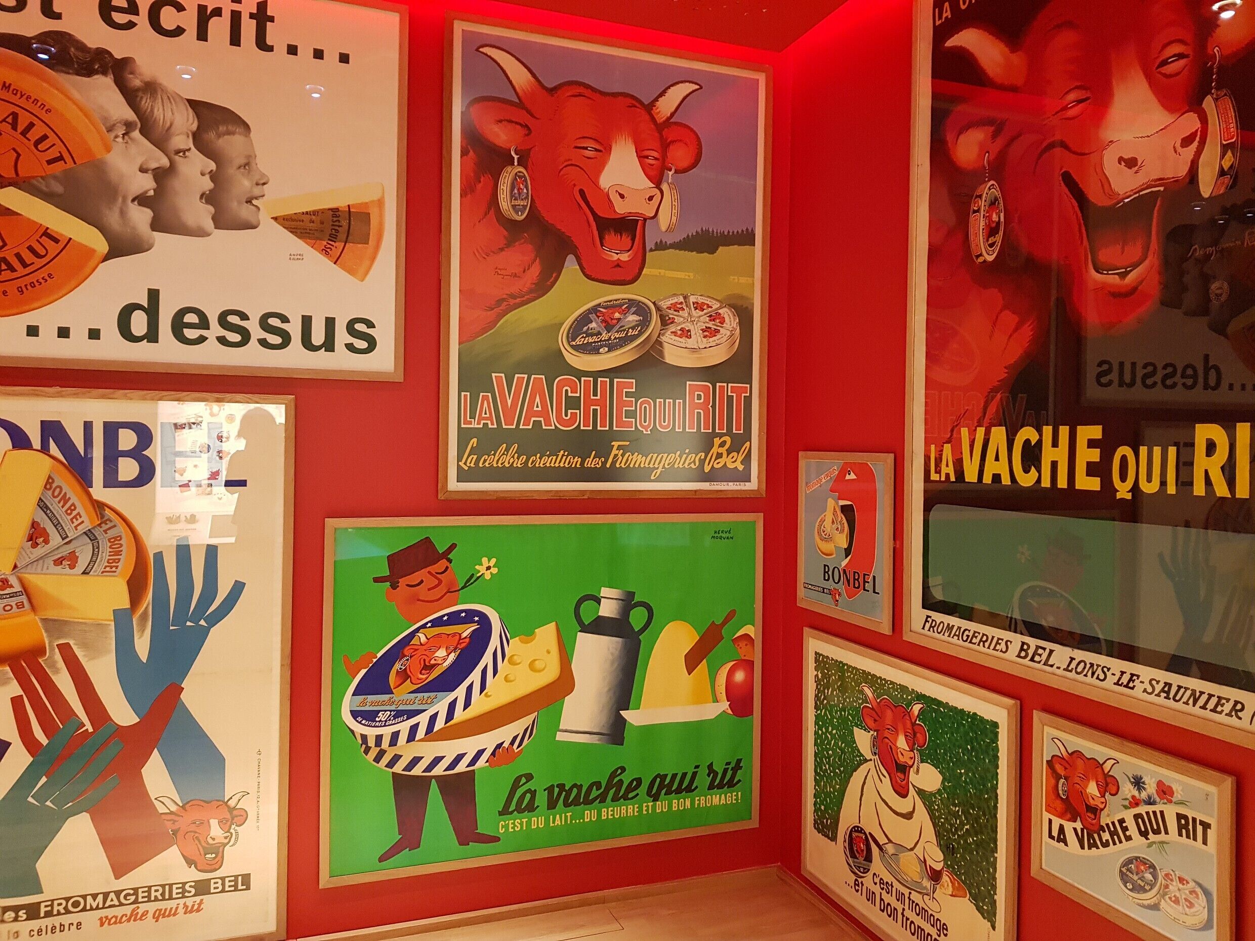 A wall with various vintage advertisements, including cheese and dairy products.