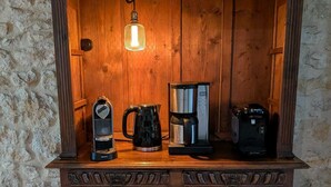 Un armari de fusta amb una cafetera, un búl·l i una forquilla per a cafè.