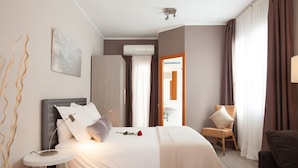 A neatly arranged bedroom with a bed, bedside table, and a chair. - Studio apartment Barcelona with terrace (Barcelone)