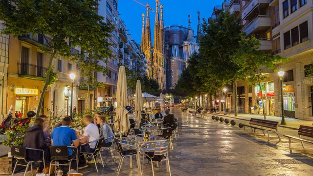 An outdoor café with tables and chairs, surrounded by trees and buildings. - Studio apartment Barcelona with terrace (Barcelone)